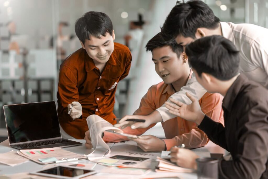 Four Bangkok email marketing experts analyze data and campaign strategies, collaborating at a desk.