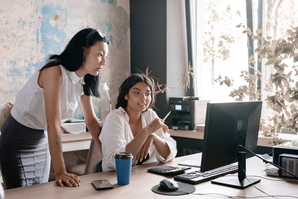 Two email marketing experts in Bangkok collaborate, reviewing data and crafting effective campaigns to grow revenue.