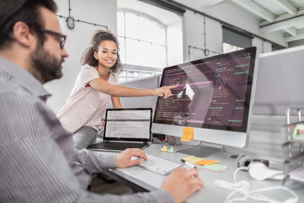 Our expert team collaboratively reviews website code on a monitor, ensuring secure updates and optimal site performance.