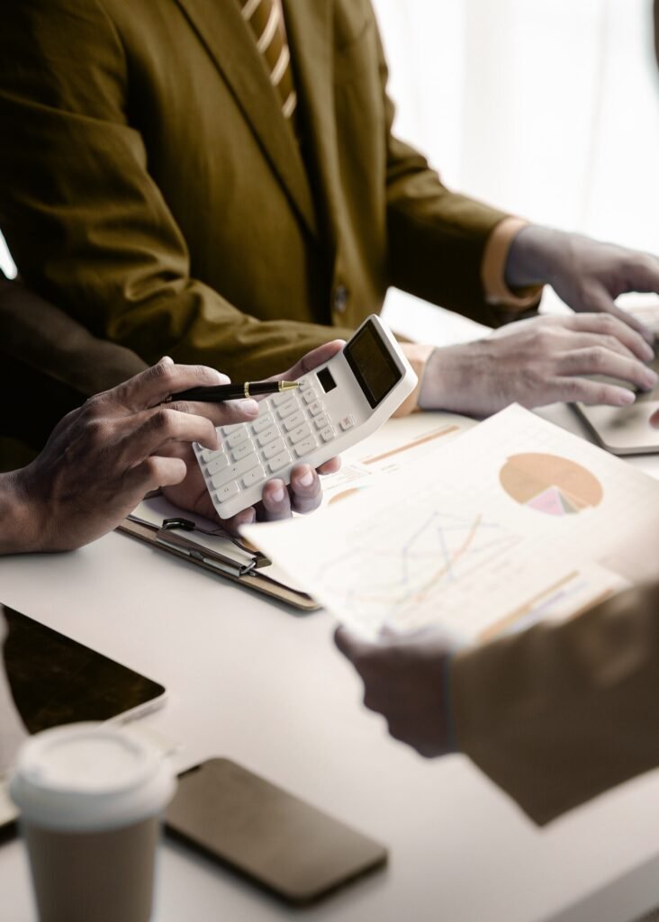 Marketing experts analyze Google Ads campaign performance using a calculator and data charts to boost ROI.