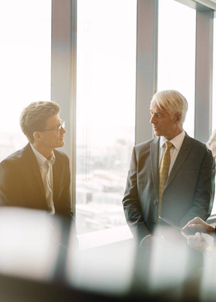 Business professionals in a bright office, strategizing for LinkedIn ad campaigns to deliver growth and ROAS.