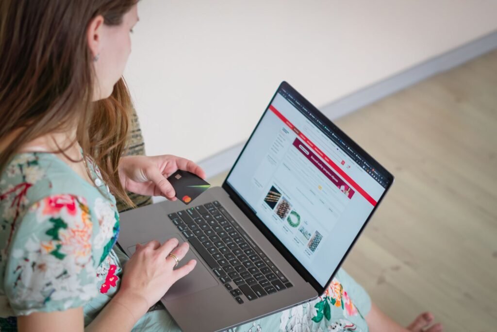 Woman making an online purchase with a credit card on a laptop, representing successful e-commerce conversions from Google Shopping.