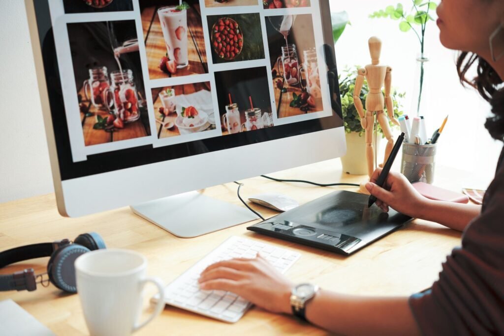 Web designer creating engaging content, editing vibrant food photography on a monitor with a graphics tablet, demonstrating design expertise for Bangkok clients.