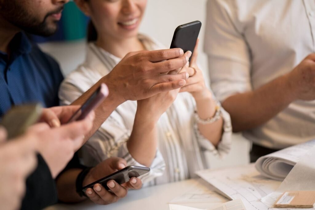Diverse group captivated by content on their smartphones, demonstrating Google Display Ad campaign effectiveness.