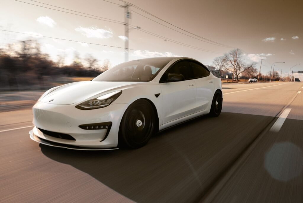 Sleek white Tesla Model 3 speeding on a highway at golden hour, representing dynamic automotive industry growth and digital marketing success.