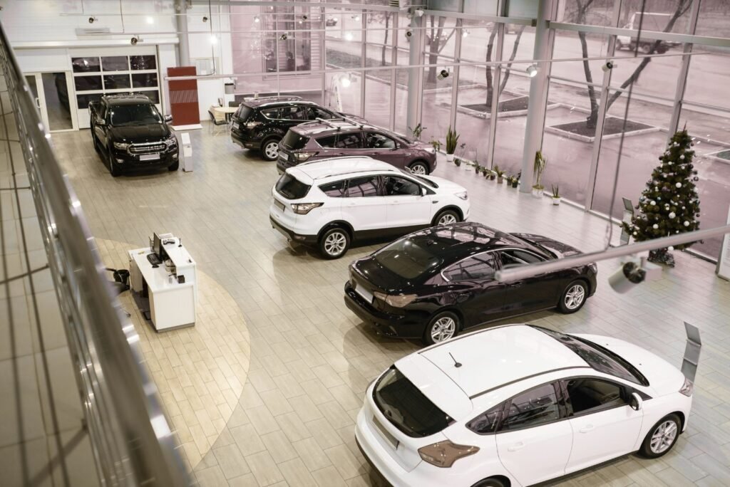 Modern auto dealership showroom with multiple new SUVs and sedans on display, highlighting the automotive sales environment.