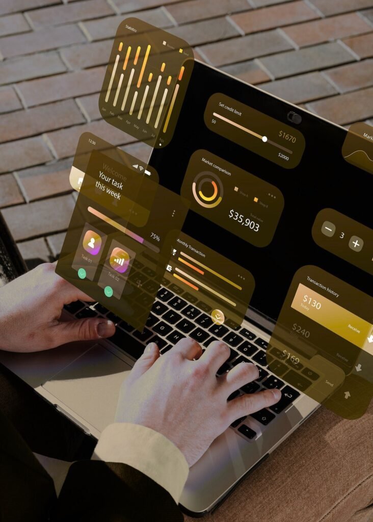 Hands on laptop, screen displaying a data analytics dashboard with graphs, market comparisons, and transaction data.