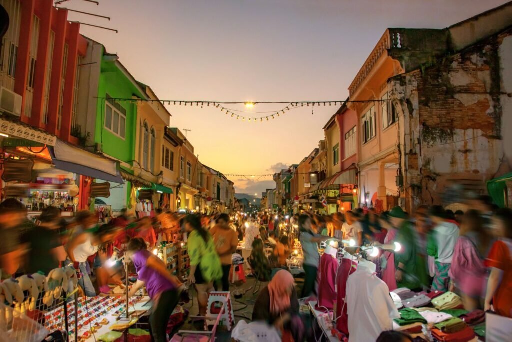 Vibrant Phuket Old Town night market bustling with people and colorful shophouses, reflecting local commerce.