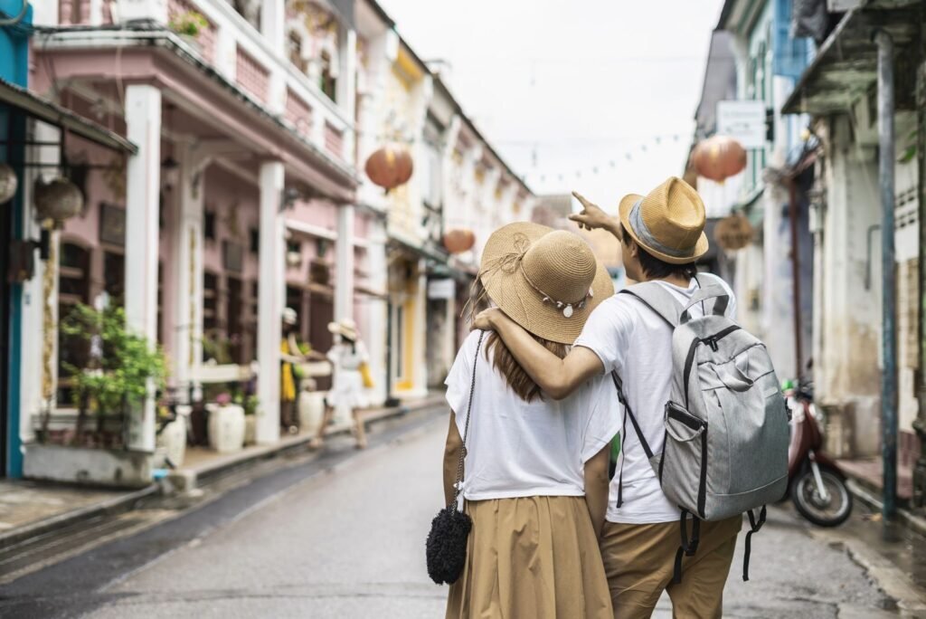 Two people exploring a vibrant Phuket street, pointing ahead, symbolizing digital marketing guidance and business growth.