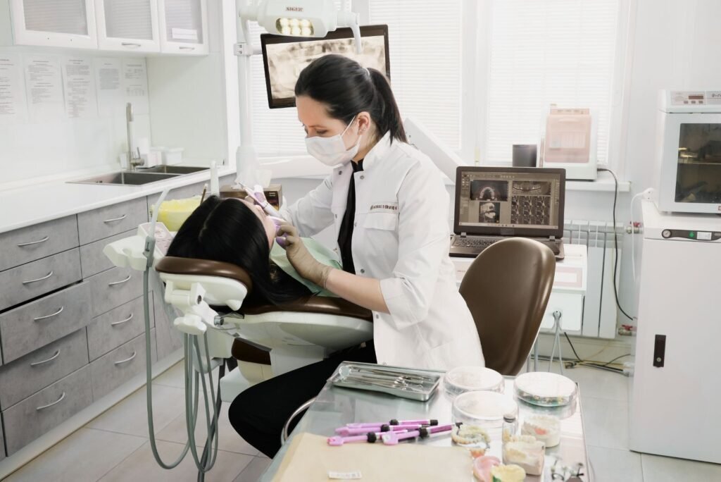 Dentist treating patient in a modern clinic, with digital X-rays displayed on screens. Essential for dental marketing.