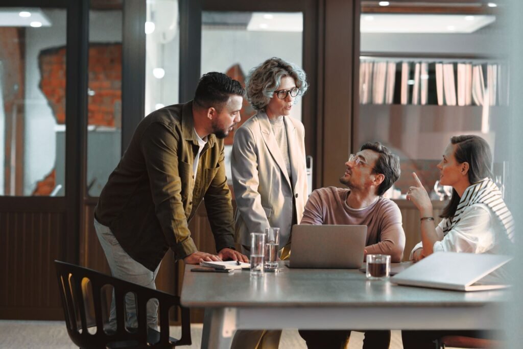 Team of four professionals actively discussing strategy for white label SEO and reseller services at a modern office table.