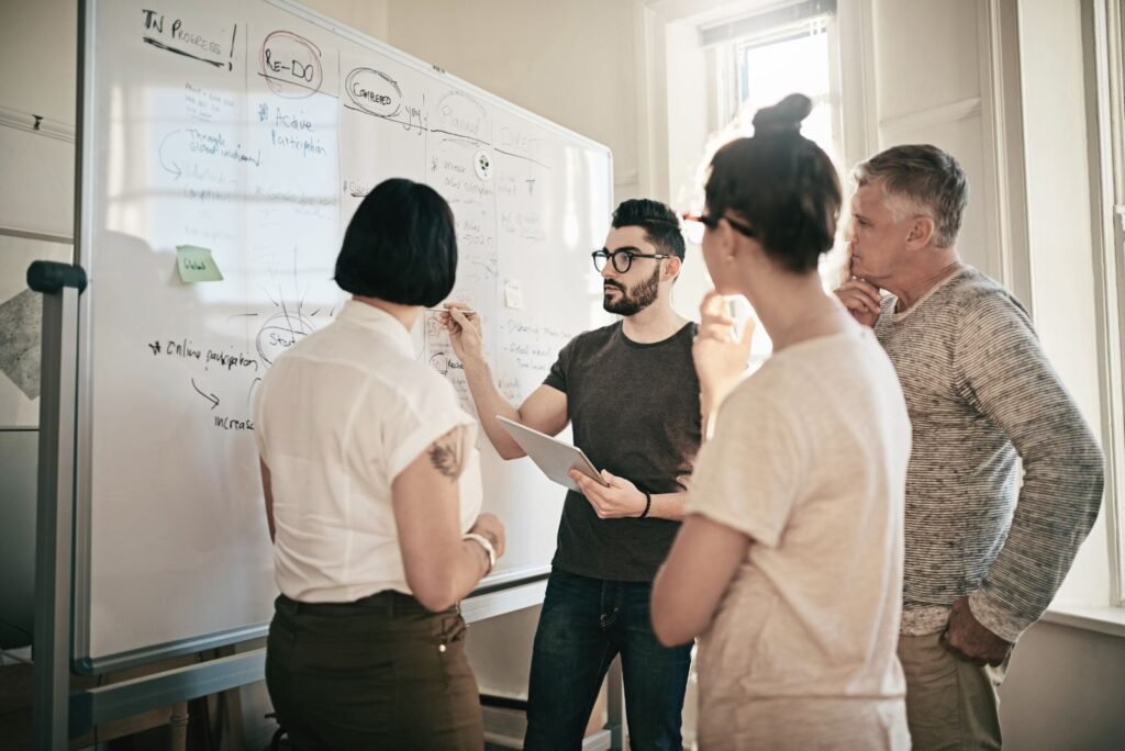 Diverse team brainstorming Google Business Profile strategy on a whiteboard, planning optimization and growth.
