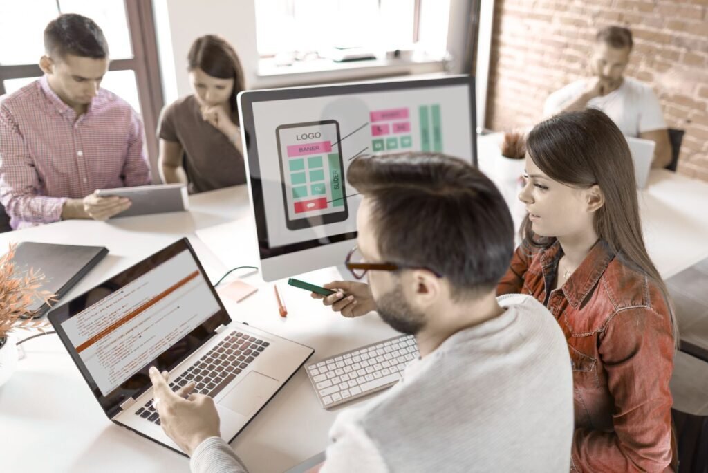 UI/UX experts collaborating on mobile app interface design and code, driving digital growth and user engagement.