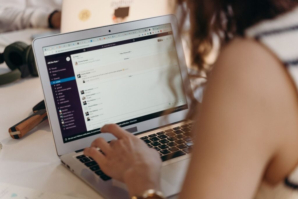 Professional from our Bangkok team managing email marketing campaigns on a laptop, collaborating with colleagues.