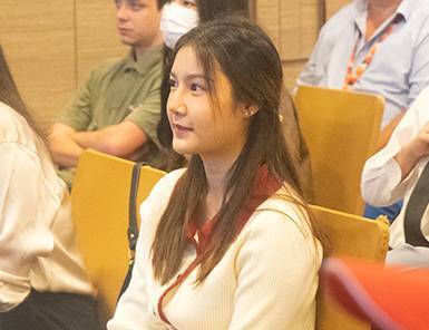 Young Asian woman, a digital marketing expert, attentively listening at a professional event. Part of our diverse team.