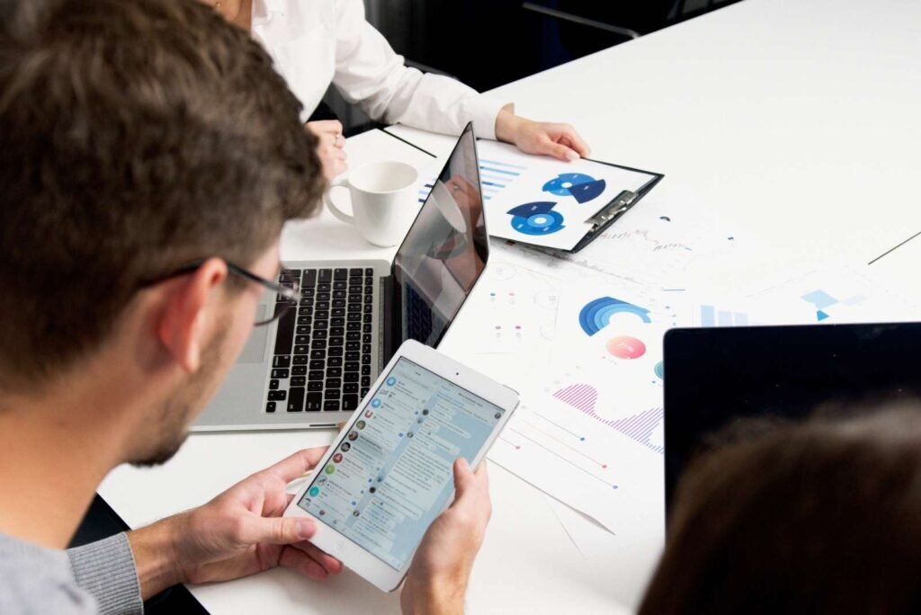Experts review Google Performance Max campaign data on laptops, tablets, and detailed charts for strategic growth.