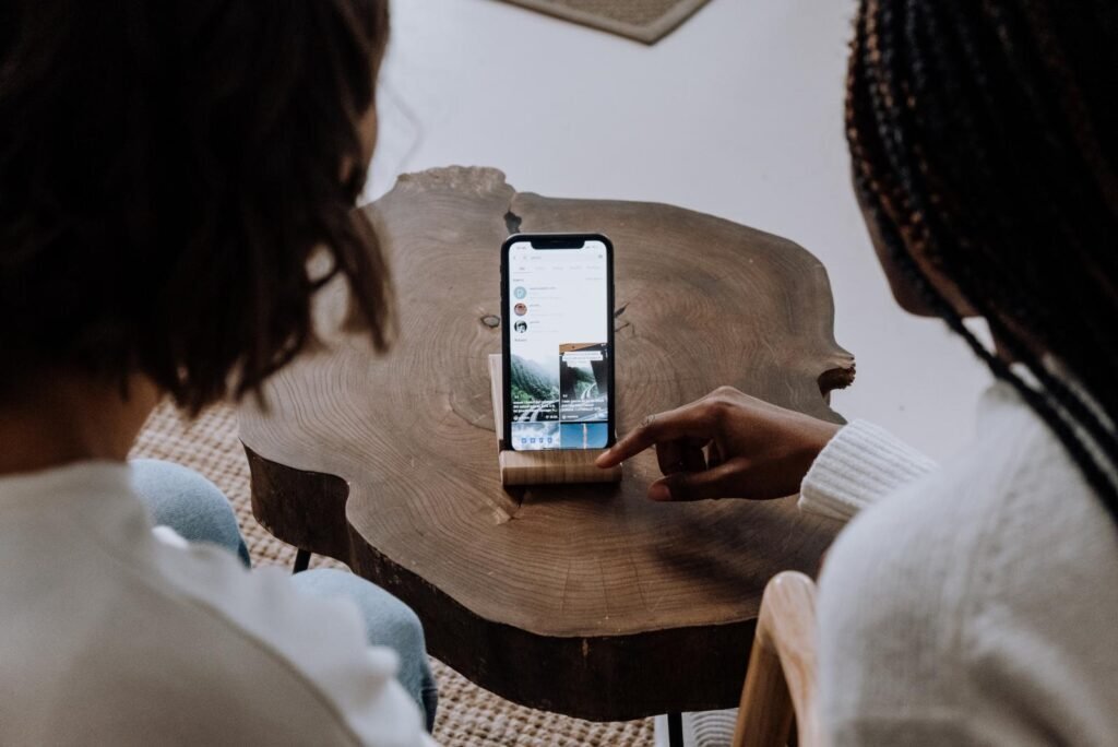 Two users viewing engaging TikTok videos on a smartphone, demonstrating scroll-stopping ad campaign potential.