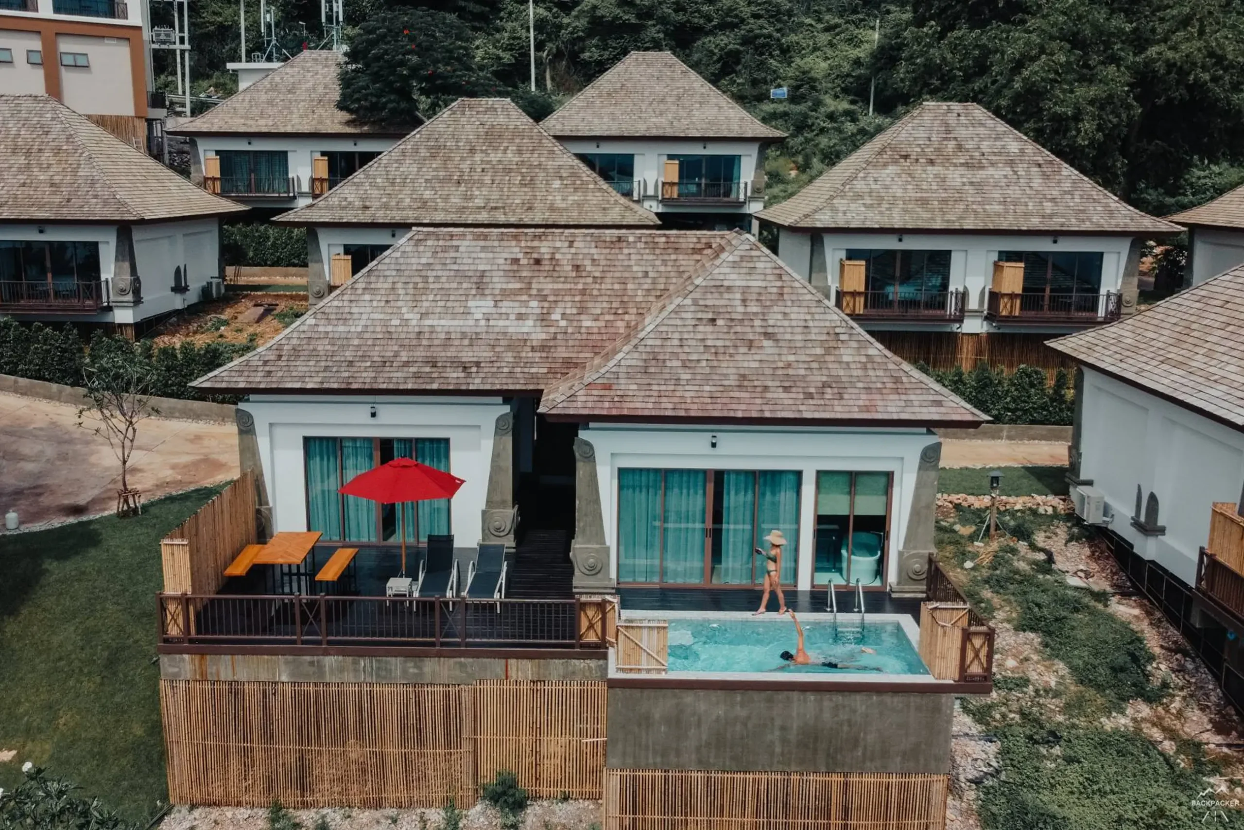 Aerial view of beautiful Thai resort villas with private pools and guests, perfect for hospitality digital marketing.