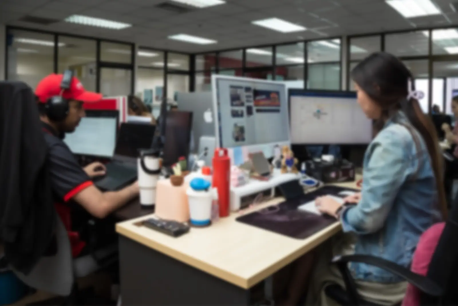 Two digital marketing professionals working at computers in Move Ahead Media's modern Bangkok office.