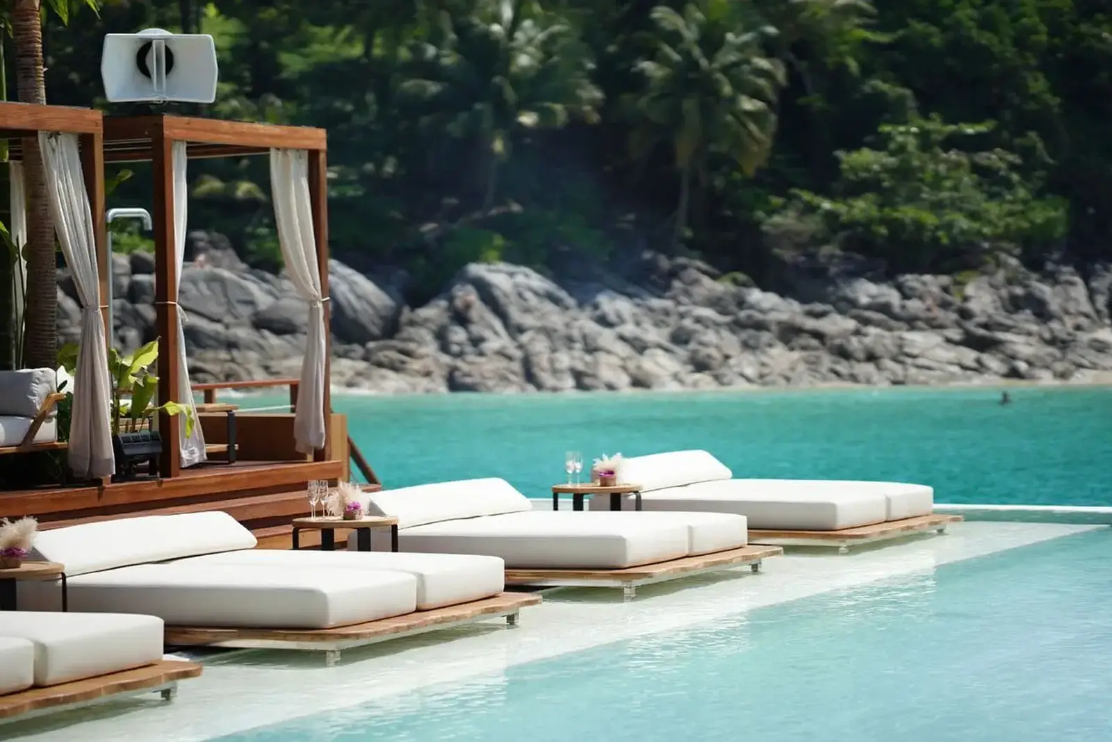 A luxurious infinity pool with white daybeds and a cabana, overlooking a tropical turquoise ocean. Highlights digital marketing success.